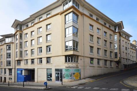 Modern corner apartment building on a sloped ci...