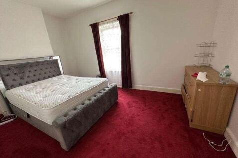 Spacious bedroom with luxurious velvet bed fram...