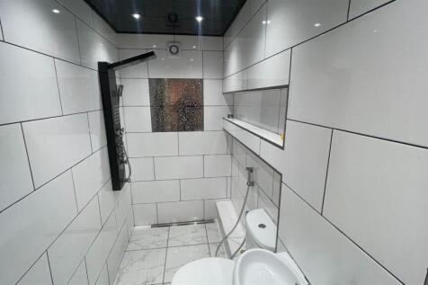 Modern walk-in shower with sleek white tiling...