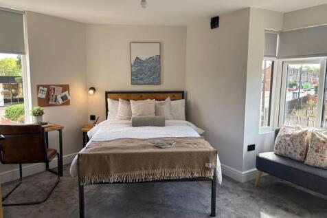 Bright, neatly styled double bedroom with a com...