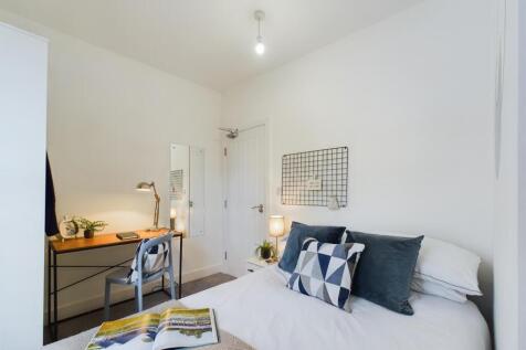 Bright and welcoming double bedroom featuring a...