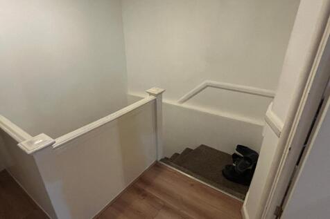 Well-maintained staircase and landing with ligh...