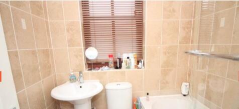 Bright tiled bathroom with a pedestal sink, WC ...