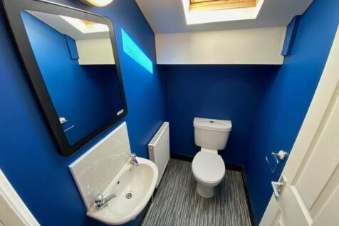 A clean and well-lit single toilet with modern ...