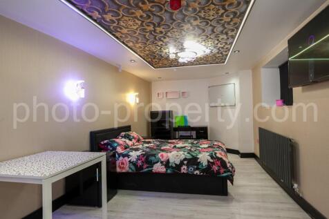 Modern double bedroom with patterned feature ce...