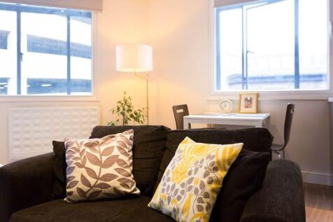Bright lounge area with cozy sofa and desk spac...