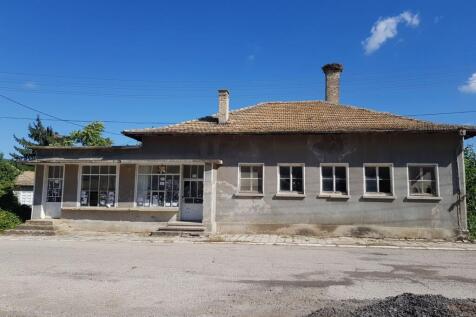 Front view of the old bakery building with tiled roof and several windows in Palamartsa village