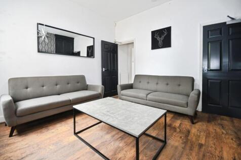 Bright, modern living room with two matching gr...