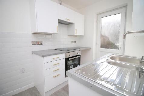 Modern white kitchen with sleek grey worktops...