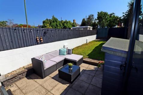 Sun-drenched private garden with stylish seatin...