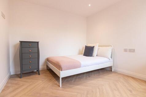 A bright and tidy single bedroom featuring a co...