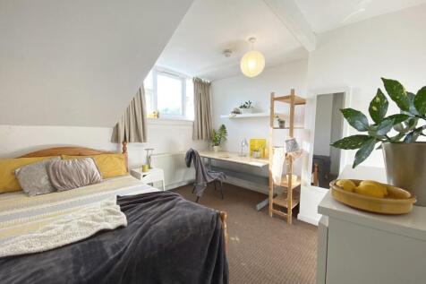 Bright, neatly styled double bedroom with a com...
