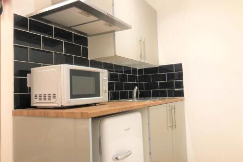 A modern kitchen space featuring sleek black ti...