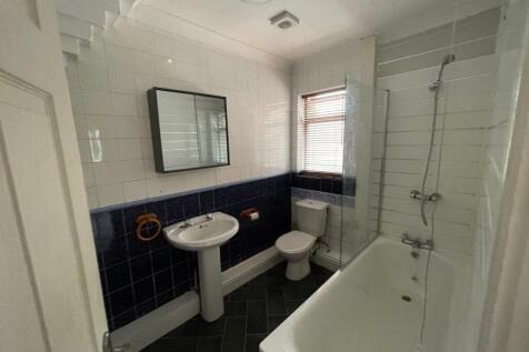 Well-equipped bathroom with a bathtub and overh...
