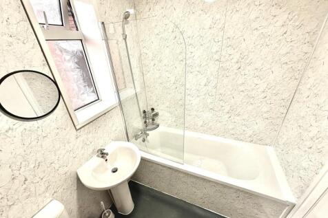 Bright, modern bathroom with a full-size bath a...