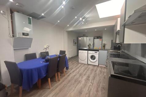 Modern shared kitchen with dining table and was...
