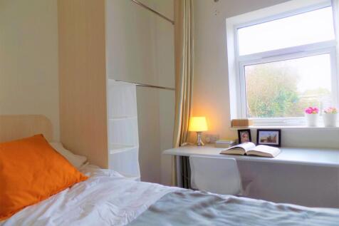 Bright and cozy single bedroom featuring a comf...