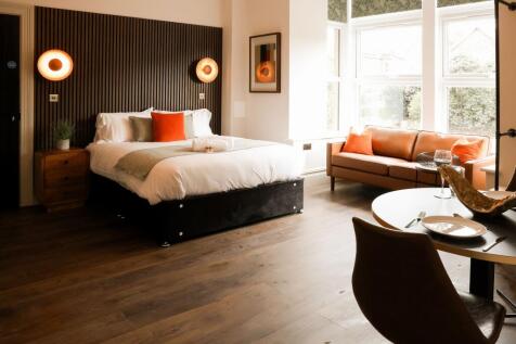 Bright stylish room with sofa and large windows...