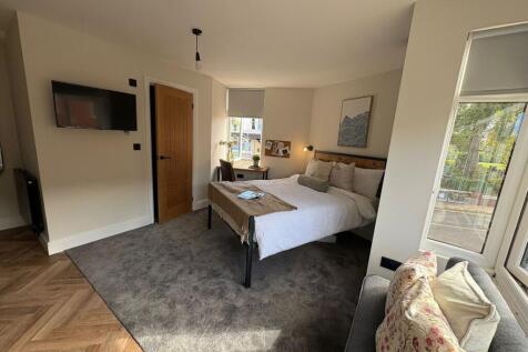 Bright, well-styled bedroom with a comfortable ...