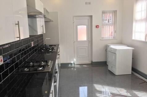 Bright modern kitchen with sleek black tiled sp...