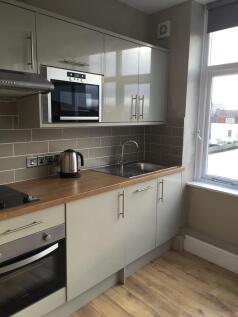 Modern kitchen with sleek gloss units and view...