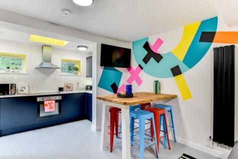 Bright modern kitchen with navy lower cabinets,...