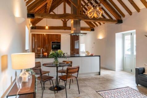 Open living kitchen with rustic beams to the eaves offering height