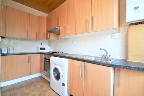Modern fitted kitchen with light wood cabinets,...