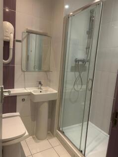 Bright, modern bathroom with a glass-enclosed s...