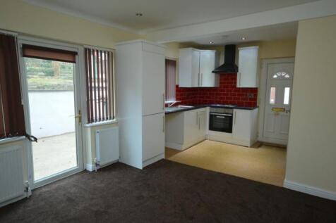 A modern kitchen with white cabinets, red tiled...