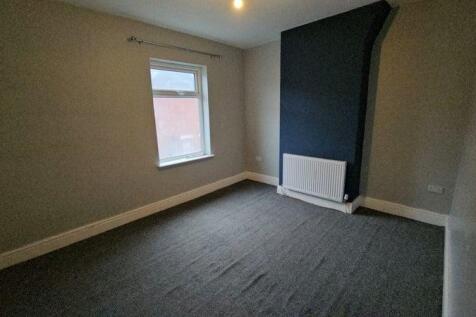 Neutral double bedroom with feature wall and ne...