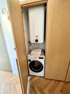 A small laundry area is concealed within a wooden 