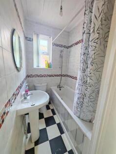 Bright bathroom with bathtub and tiled walls...