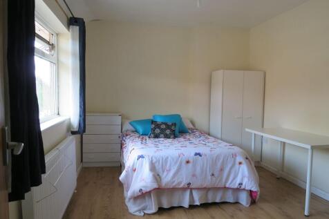 Bright, neat bedroom with a double bed dressed ...