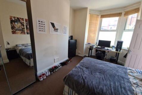 A well-lit bedroom featuring a double bed, ampl...