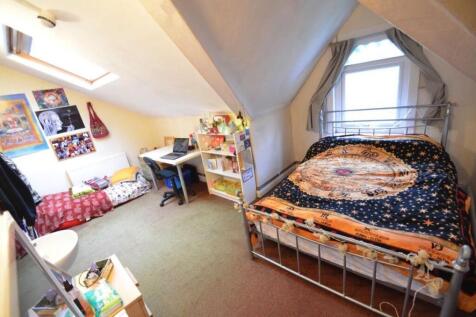 Bright attic double bedroom with a metal-framed...