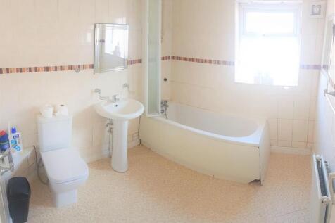 Bright, well-maintained bathroom with a curved ...
