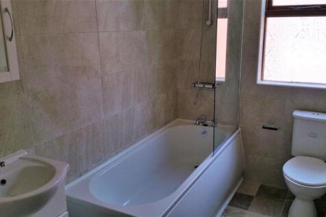 Bright, modern bathroom with a bathtub/shower c...