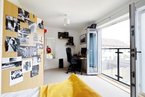 Bright, modern bedroom with a workspace and lar...