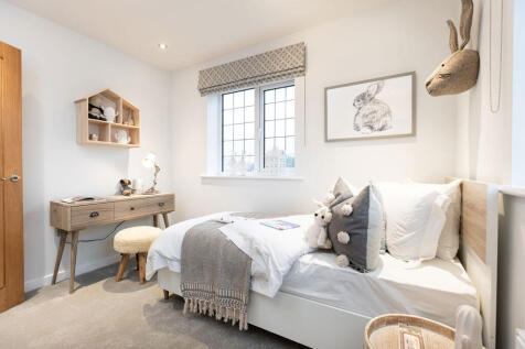 A cozy and inviting bedroom with a wooden desk, shelves, and a framed artwork on the wall