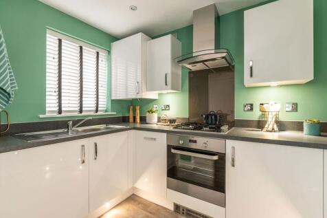 Modern 3-sided kitchen is found off the hallway at the front of the home