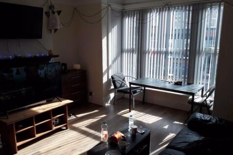 Bright and spacious living room with large wind...