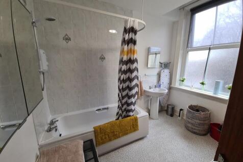 Bright, well-kept bathroom featuring a bathtub ...
