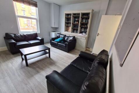 A spacious and well-lit living room featuring m...