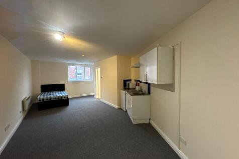 Spacious and bright living area with large wind...