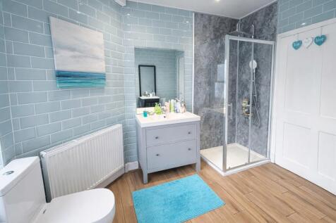 Bright, modern bathroom with a framed glass sho...