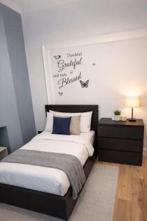 Bright, neatly styled single bedroom with a com...