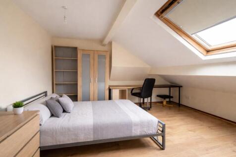 Bright attic bedroom with desk and skylight...