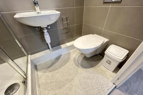 Modern tiled bathroom with shower and wall-moun...