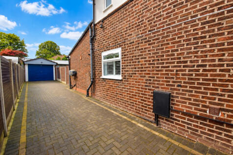 Tidy Brick Driveway to Blue Garage